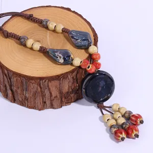 Closeup detail of retro ethnic style handmade ceramic pendant necklace sweater chain accessory.