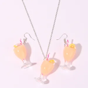 Close-up detail of cute resin juice glass pendant necklace and earrings set with lemon slice.