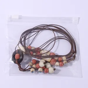 Detailed view of bohemian ceramic bead long necklace with braided cord, handmade style accessory.