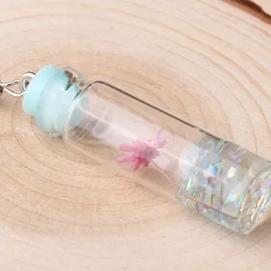 Close-up detail shot of the cute dried flower glass drift bottle pendant with colorful flakes.