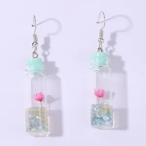 Miniature drift bottle earrings with pink flower and glitter, cute wishing bottle jewelry.