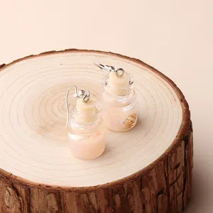 Detailed close-up of summer beach wishing bottle earrings with miniature shells and pearls.