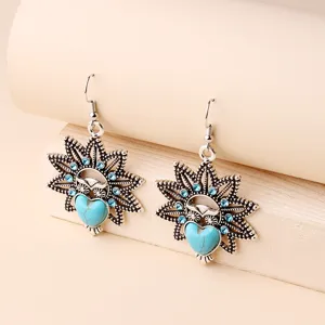 Close-up detail shot of vintage owl dangle earrings featuring turquoise heart and blue crystals.