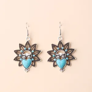 Detailed view of vintage bohemian owl dangle earrings with turquoise heart and blue rhinestones.
