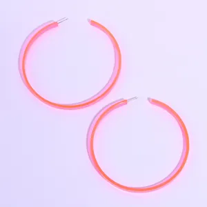 Neon pink oversized acrylic hoop earrings for women, trendy chic street style fashion jewelry.