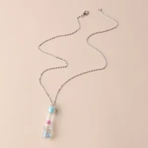Drift bottle pendant necklace detail, featuring a clear glass vial with tiny dry flower inside.