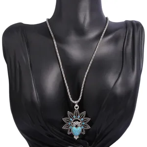 Vintage owl pendant necklace with turquoise and blue rhinestones, boho style detail shot.
