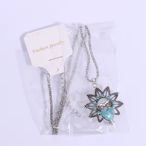 Detailed view of vintage owl pendant necklace featuring turquoise heart stone and blue crystal rhinestones.