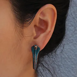 Detailed close-up view of vintage style blue cobra snake stud earrings worn on the ear.