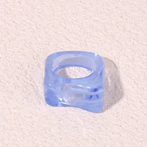 Detailed close-up of blue geometric acrylic ring, trendy transparent resin fashion jewelry.