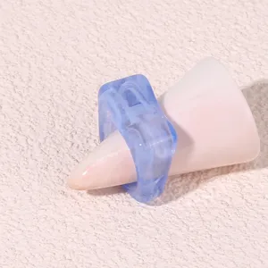 Close-up detail of the modern blue geometric acrylic resin ring displayed on a pink cone stand.