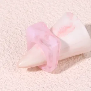 Close-up detail of a stylish pink geometric acrylic resin chunky ring, modern fashion jewelry.