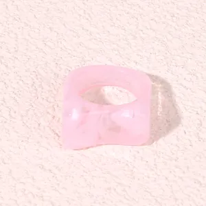 Pink acrylic geometric ring detail close-up, trendy minimalist resin fashion jewelry.