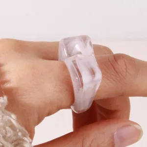 Close-up detail of geometric acrylic resin ring, trendy minimalist marbled fashion jewelry.