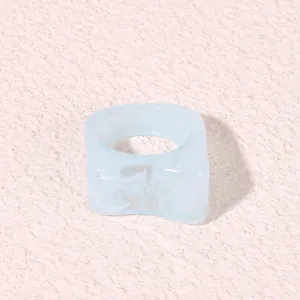 Closeup of light blue geometric acrylic ring showing unique marbled texture and square shape.