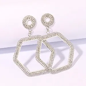 Close-up of sparkling rhinestone geometric drop earrings, silver-toned fashion detail view.