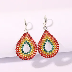 Close-up detail of colorful rhinestone teardrop earrings, vibrant multi-color crystal concentric design.