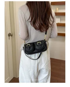 Chique zwarte lederen schoudertas met retro dubbele voorzakken en elegante metalen gespen.