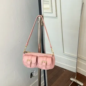 Roze retro schoudertas voor dames, chique baguette tas met dubbele voorzakken en metalen gespen.