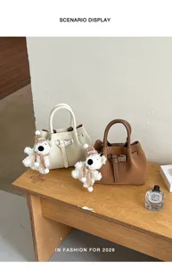 Vista detallada de elegantes bolsos con bonitos colgantes de oso en escritorio.