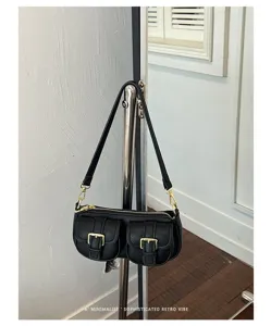 Zwarte schoudertas met voorzakken en retro design, stijlvol accessoire voor dagelijks gebruik.