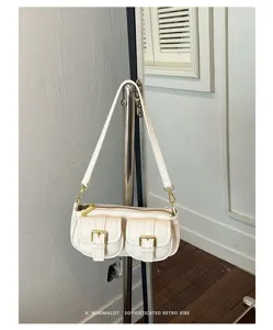 Witte minimalistische schoudertas met twee voorzakken en chique retro gouden hardware details.