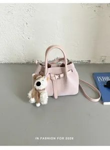Vista detallada del elegante bolso tipo cubo rosa tejido con textura y lindo dije de oso.
