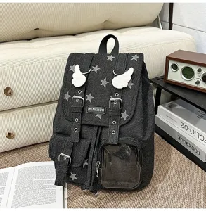 Detailed view of dark denim backpack featuring white star patterns and cute wing decor.