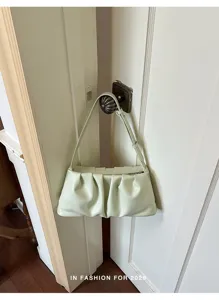Light green pleated underarm shoulder bag, trendy soft leather cloud bag detail view.