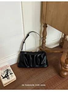 Detail view of black ruched shoulder bag, soft PU leather dumpling bag for women fashion.