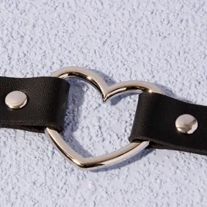 Collier ras de cou en cuir noir style punk avec anneau de cœur en métal argenté et rivets.