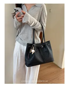 Black woven leather tote bag detail, large capacity shoulder bag with belt accent.