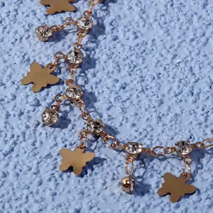 Detailed shot of gold metal butterfly anklet with sparkling rhinestones chain accessory.