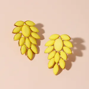 Detailed closeup of vibrant yellow acrylic cluster earrings with gold metal settings.