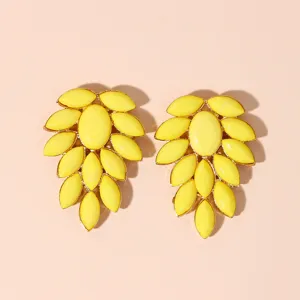 Yellow acrylic stone statement earrings with gold-toned metal detailing in leaf cluster.
