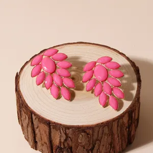 Detailed shot of bold pink acrylic leaf cluster earrings with gold-tone metal trim.