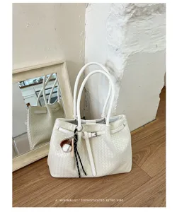 White woven tote bag detail showing intricate leather weave pattern and modern minimalist vibe