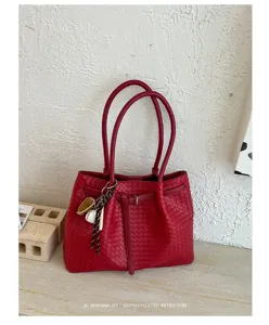 Close-up of red woven leather tote bag detail, featuring intricate intrecciato pattern design.