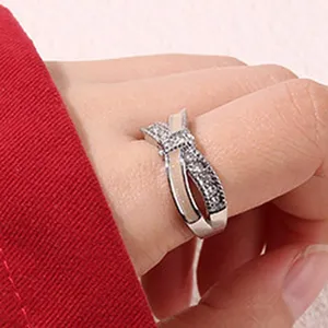 Gros plan detail de la bague noeud geometrique en argent avec email blanc et petits cristaux.