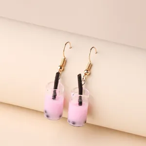 Primo piano dettagliato di orecchini pendenti tazza bubble tea rosa, design dolce e alla moda.