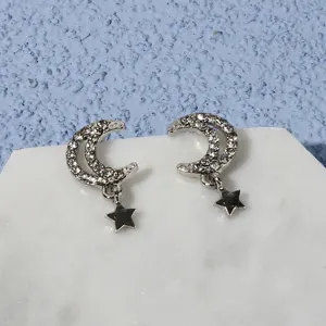 Silver rhinestone moon and star dangling stud earrings, exquisite jewelry detail view.