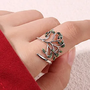 Bague branche d'arbre en metal avec feuilles emaillees vertes, design ouvert chic.