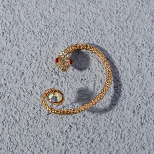 Close-up detail of a fashion gold snake ear cuff, sparkling rhinestones and colorful crystal.
