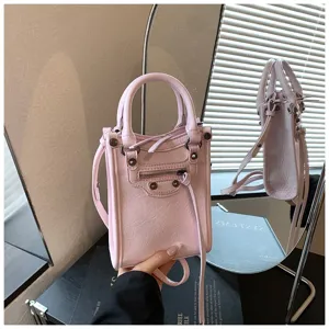 Pink mini vertical leather handbag for women, stylish crossbody phone bag with studs and zipper.