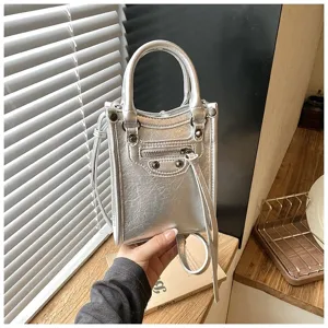 Silver metallic mini crossbody phone bag, detailed view showing chic motorcycle style studs.