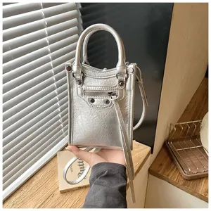 Detail view of silver metallic mini phone bag, simple versatile crossbody design for women.