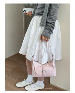 Roze retro schoudertas voor dames, stijlvolle minimalistische dumpling tas detailweergave.