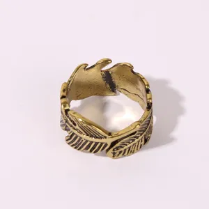 Gros plan detaille d'une bague vintage de couleur or en forme de plume elegante en alliage.