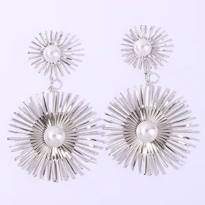 Silver starburst dangle earrings with faux pearls, showcasing intricate metal ray details.