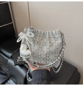 Silver rhinestone chain bucket bag with pearl lace bow and heart charm for stylish women.